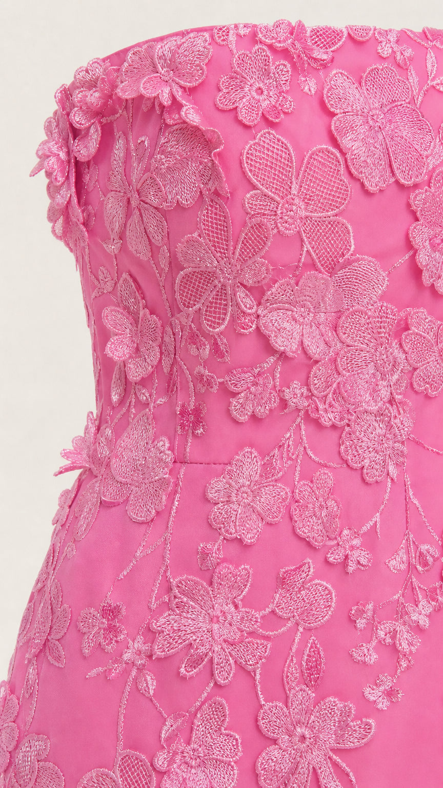 Close-up detail of textured floral appliques on pink bodice