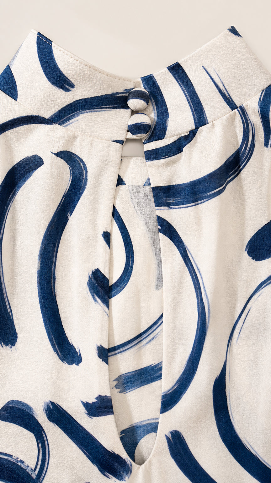 Close-up detail of high mock neckline and button closure