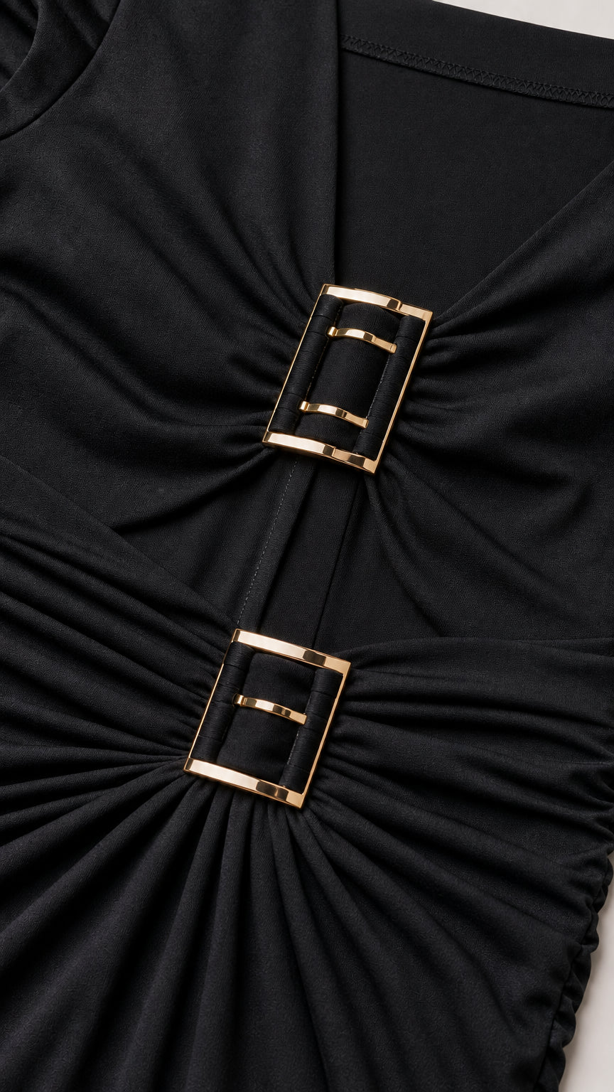 Close-up of metallic buckle accents on black dress bodice