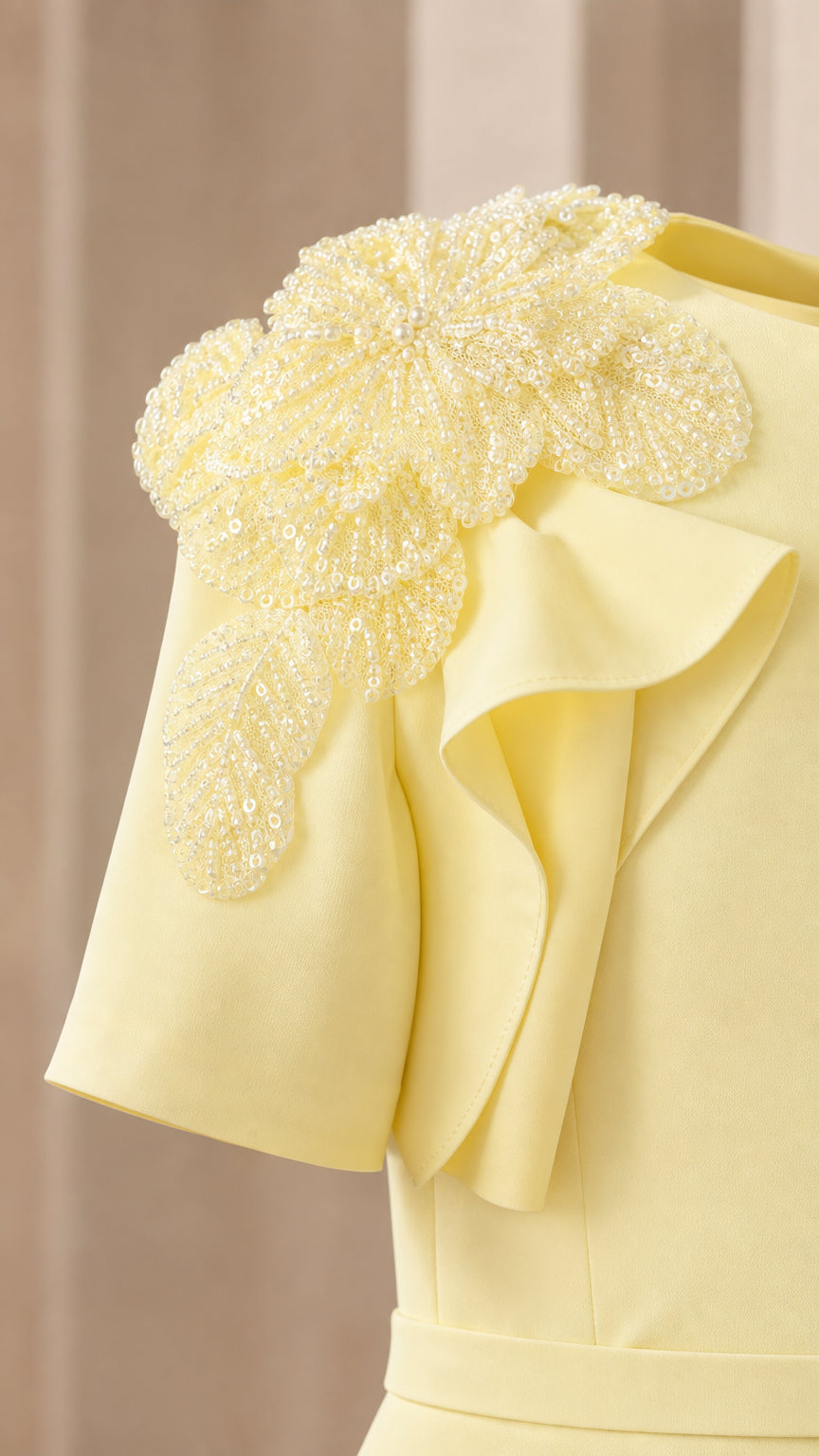 Close-up of beaded floral shoulder applique and ruffle sleeve