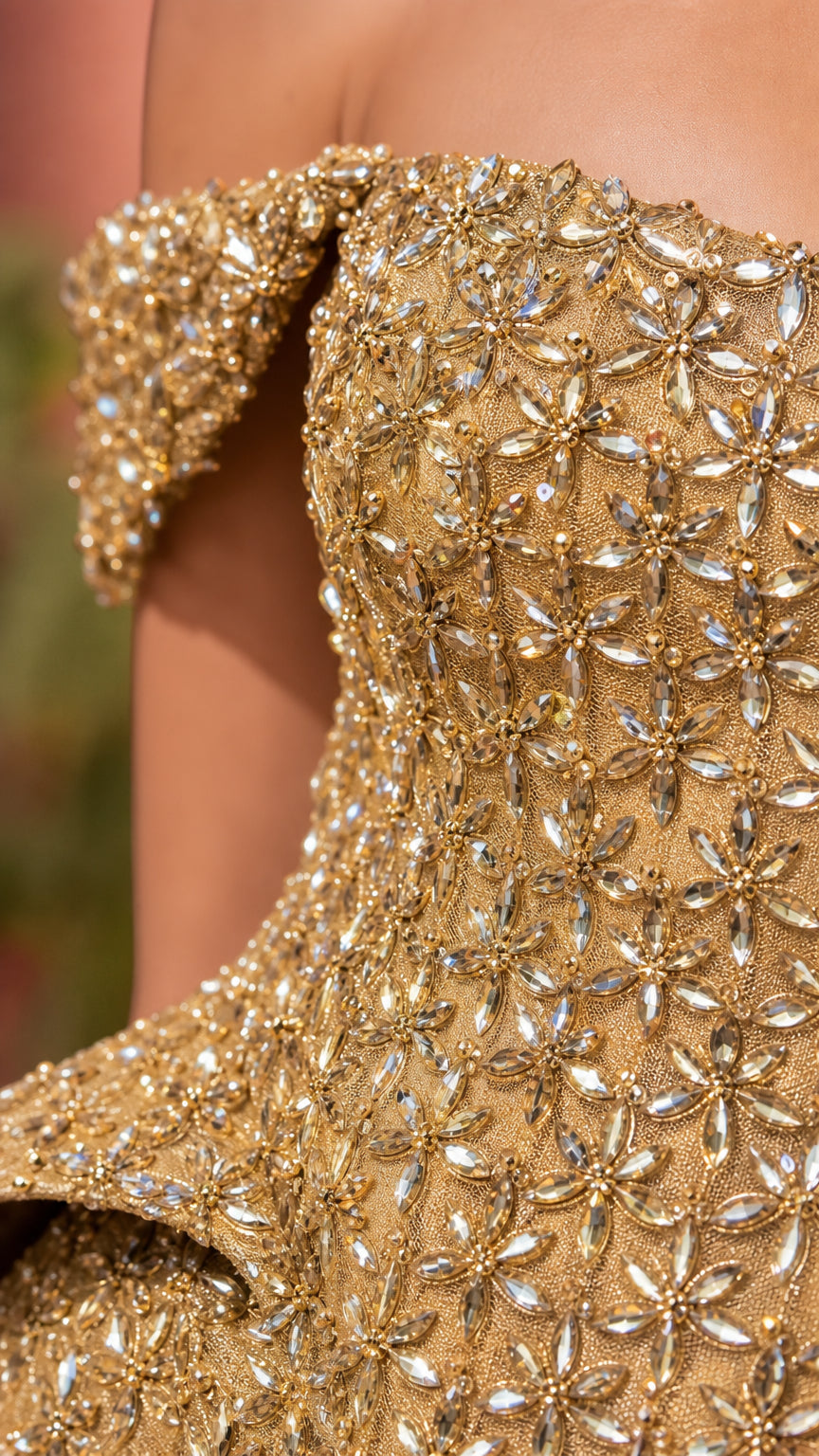 Close-up detail shot of intricate crystal beadwork and peplum construction on gold gown