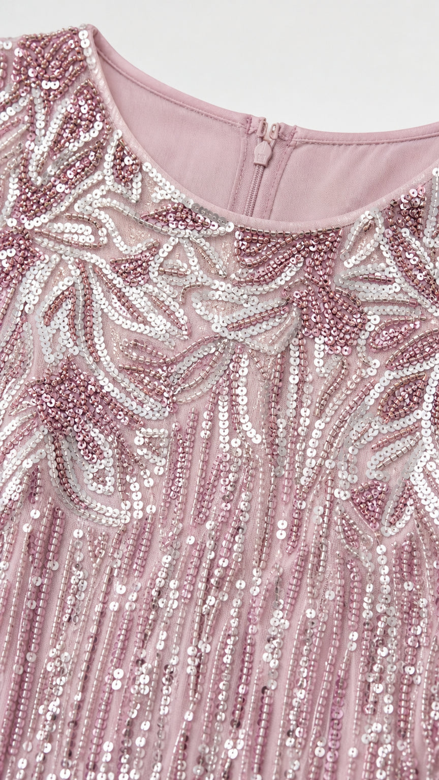 Close-up of intricate sequin and leaf embroidery pattern on pink bodice