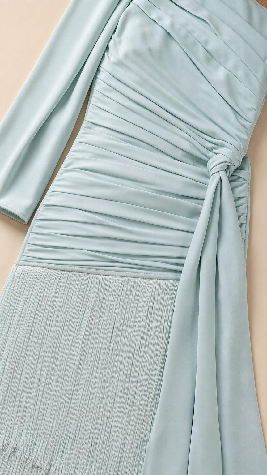 Close-up detail of ruching and fringe hem on light blue skirt