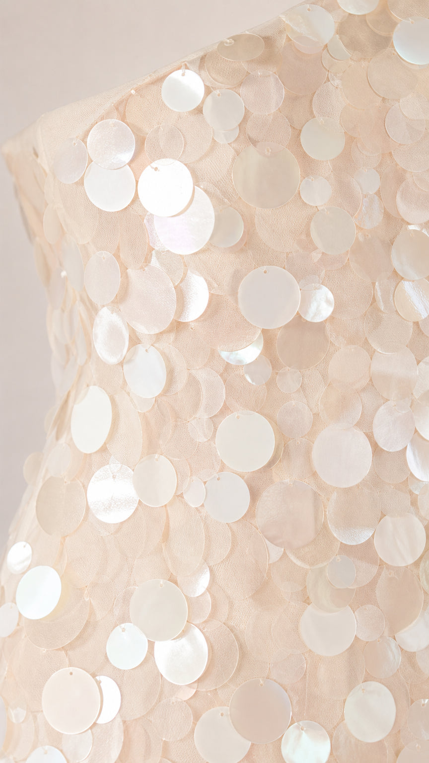 Close-up detail of round sequins on the dress fabric