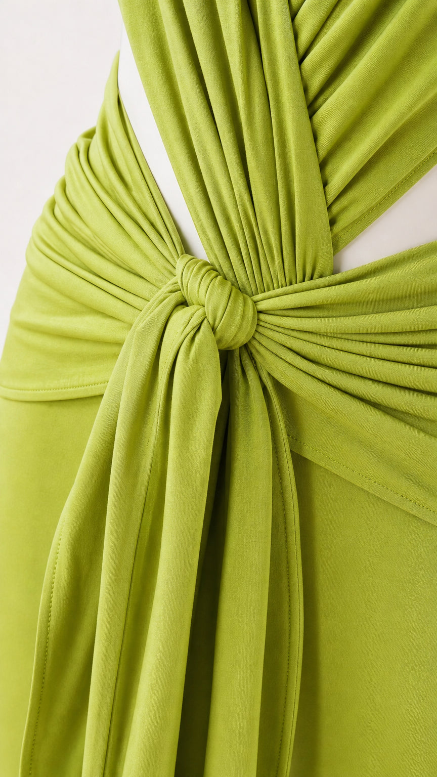 Close-up detail of the front tie knot and draped fabric on lime green jumpsuit