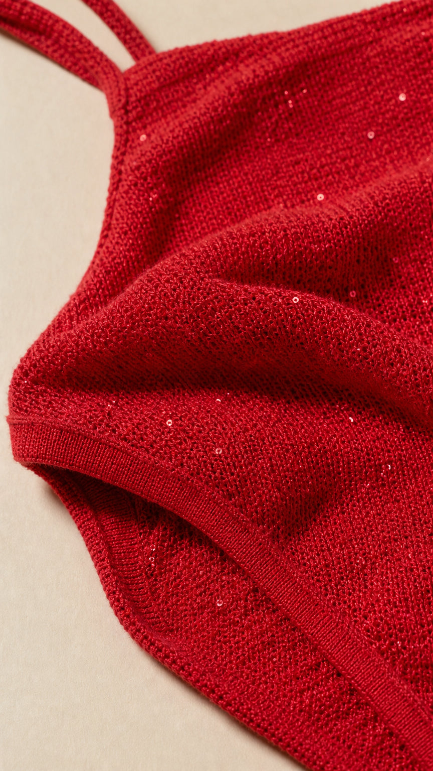 Close-up detail of textured red knit fabric with subtle shimmer