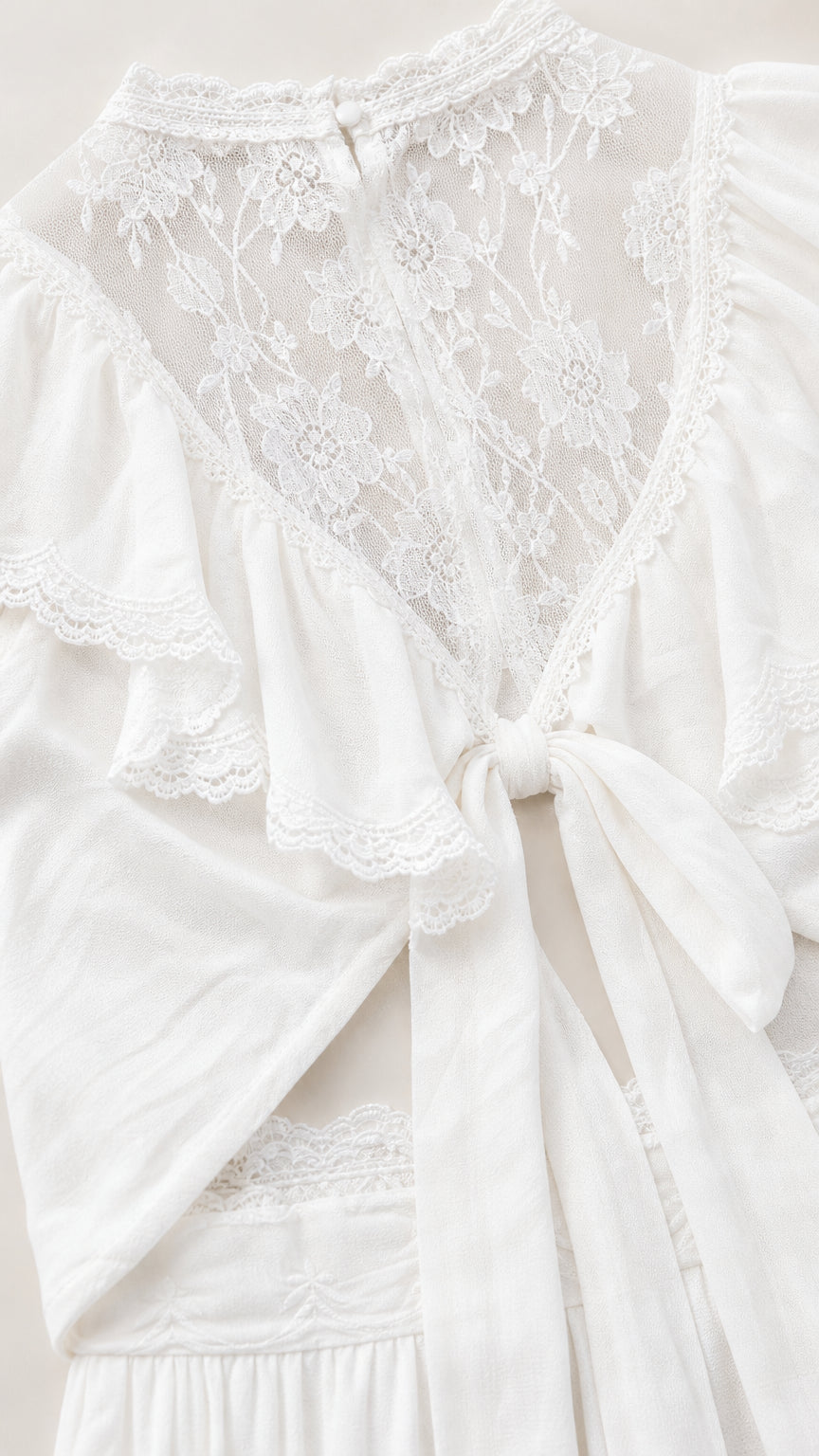Close-up flat lay of white lace neckline and back tie detail