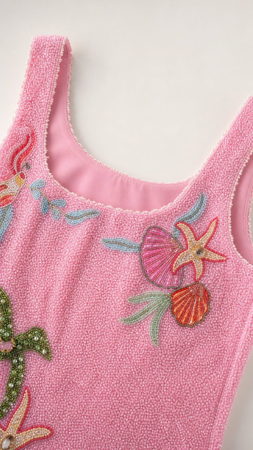 Close-up detail of scoop neckline and beadwork on pink dress