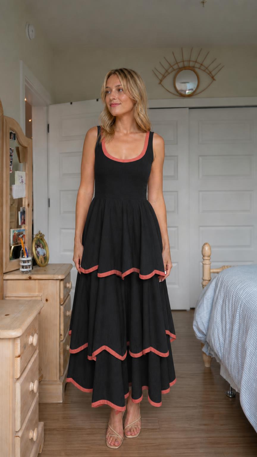 Front view of woman wearing black tiered maxi dress