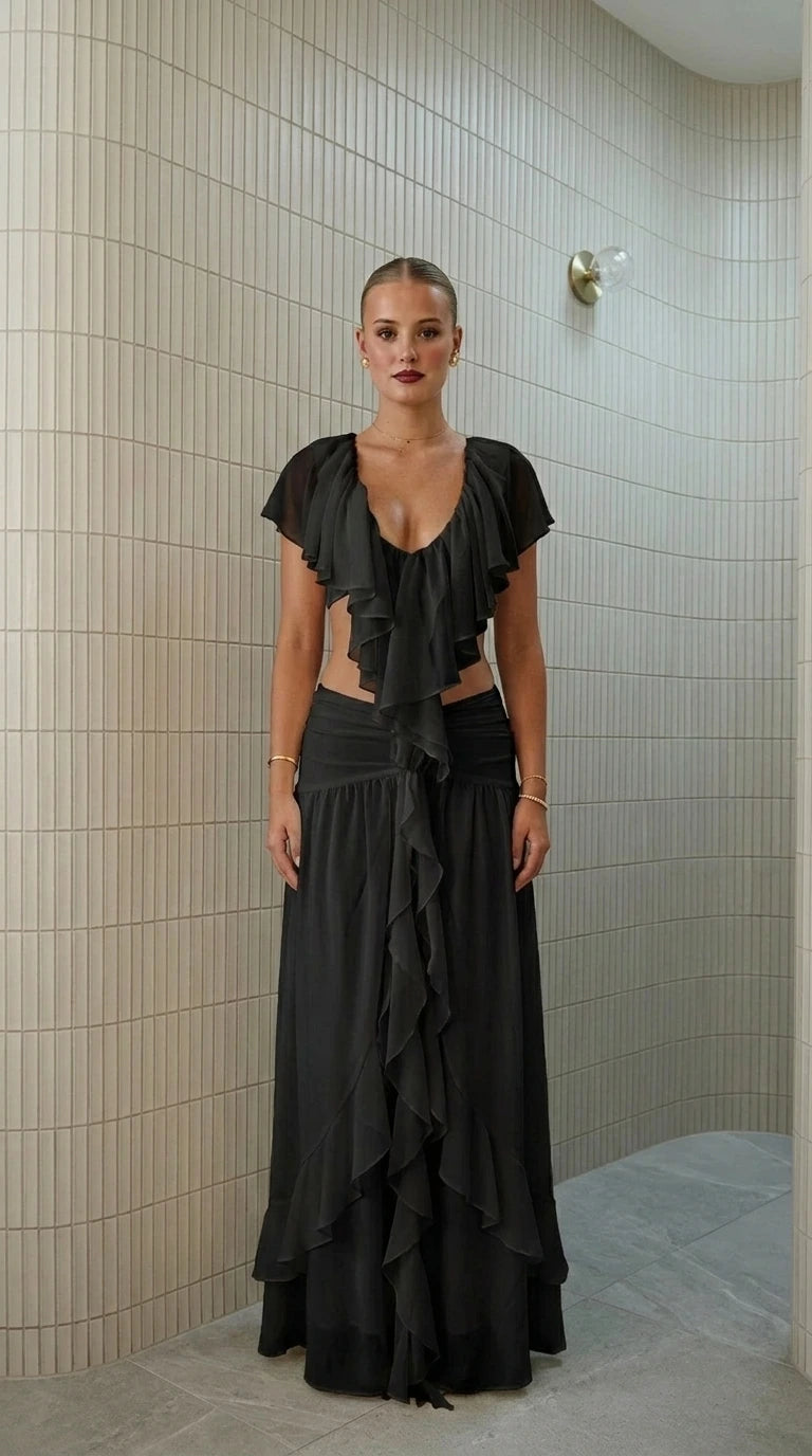 Front view of model wearing black ruffled two-piece maxi set