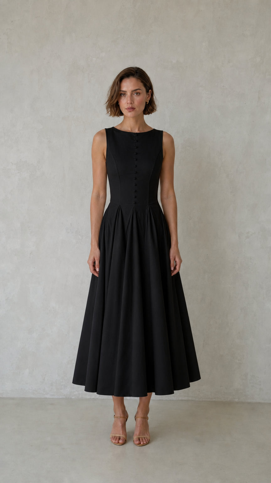 Front view of woman wearing black sleeveless pleated midi dress