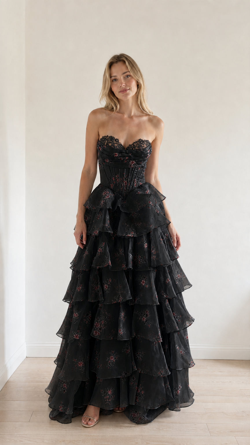 Model wearing black floral tiered ruffle strapless evening gown