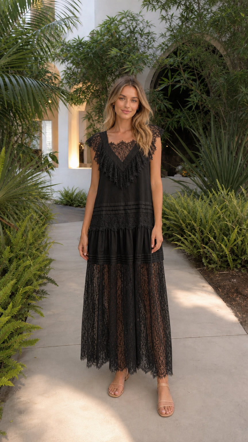 Front view of model in black lace tiered maxi dress