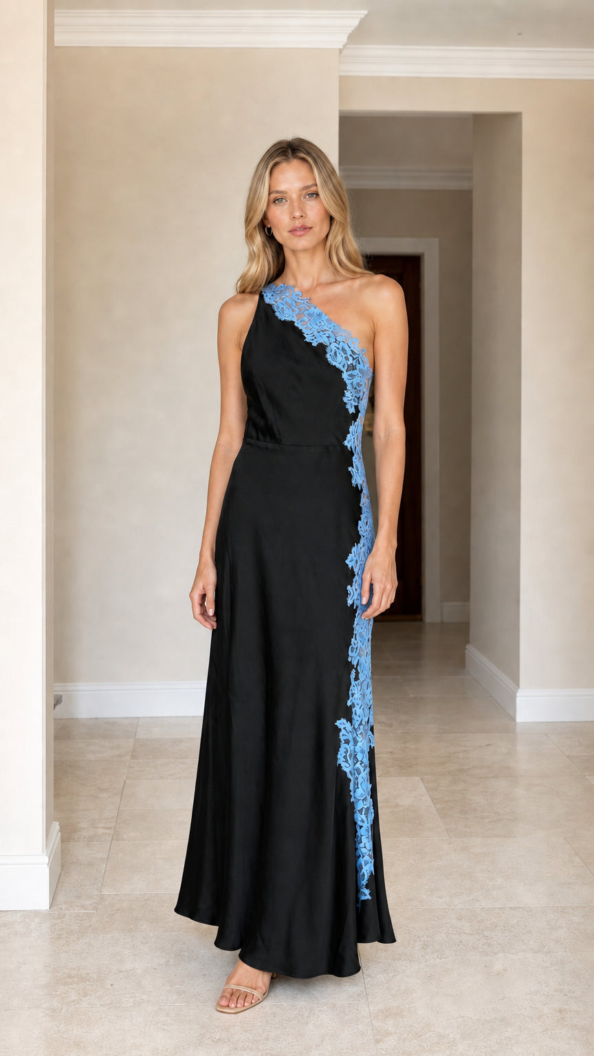 Front view of woman wearing black one-shoulder satin maxi dress with blue lace applique