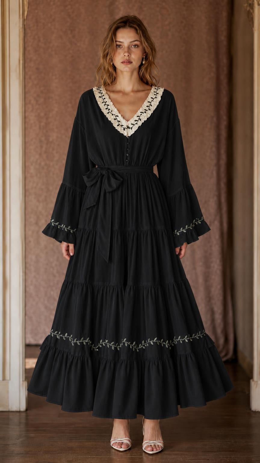 Black women's tiered maxi dress with V-neckline, botanical trim, bell sleeves, and side tie