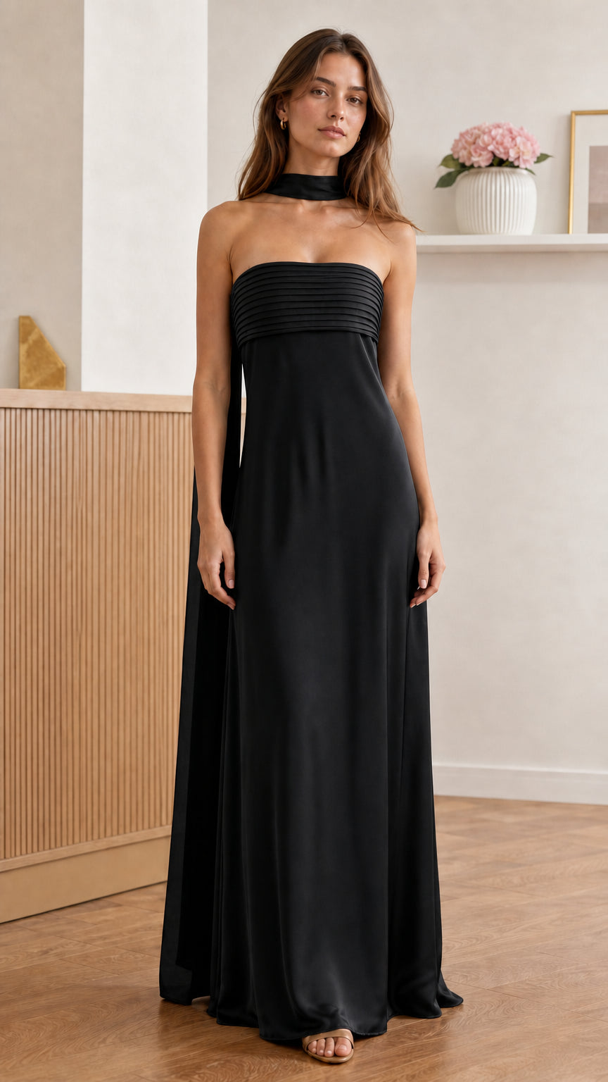Front view of model wearing black pleated strapless maxi dress