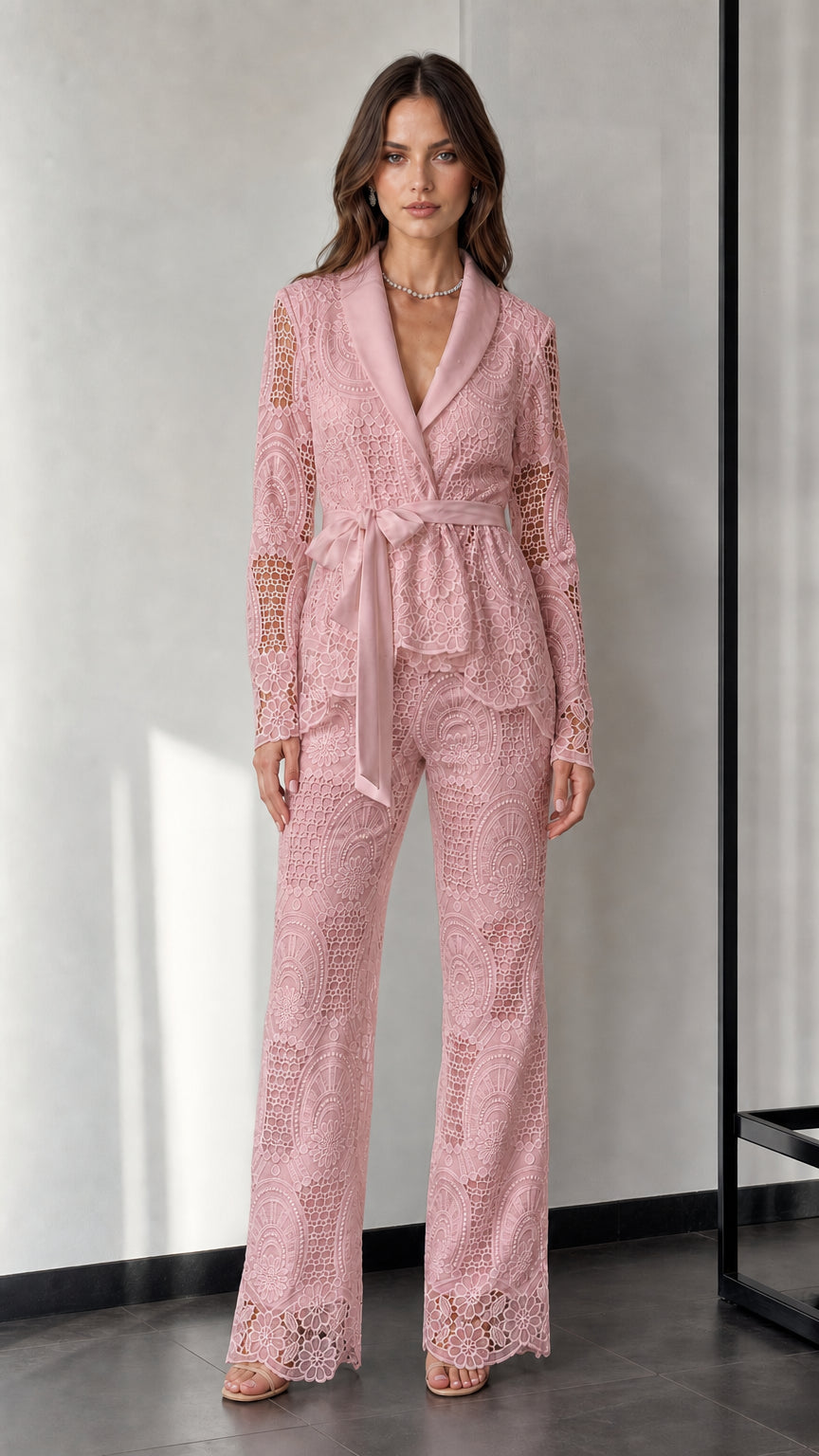Woman wearing pink lace blazer and trousers set