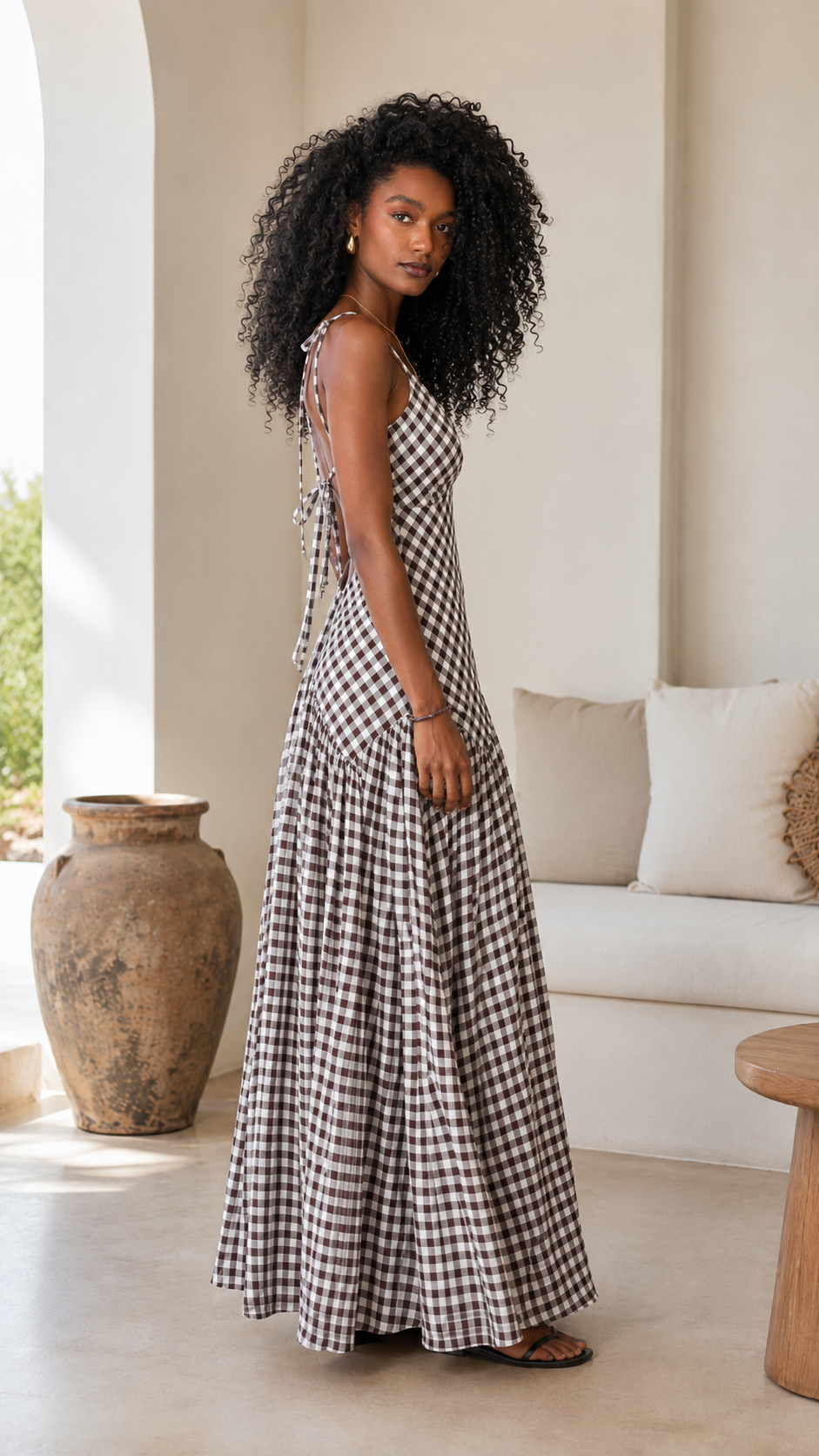 Side view of black gingham maxi dress showing slim fit bodice and long skirt