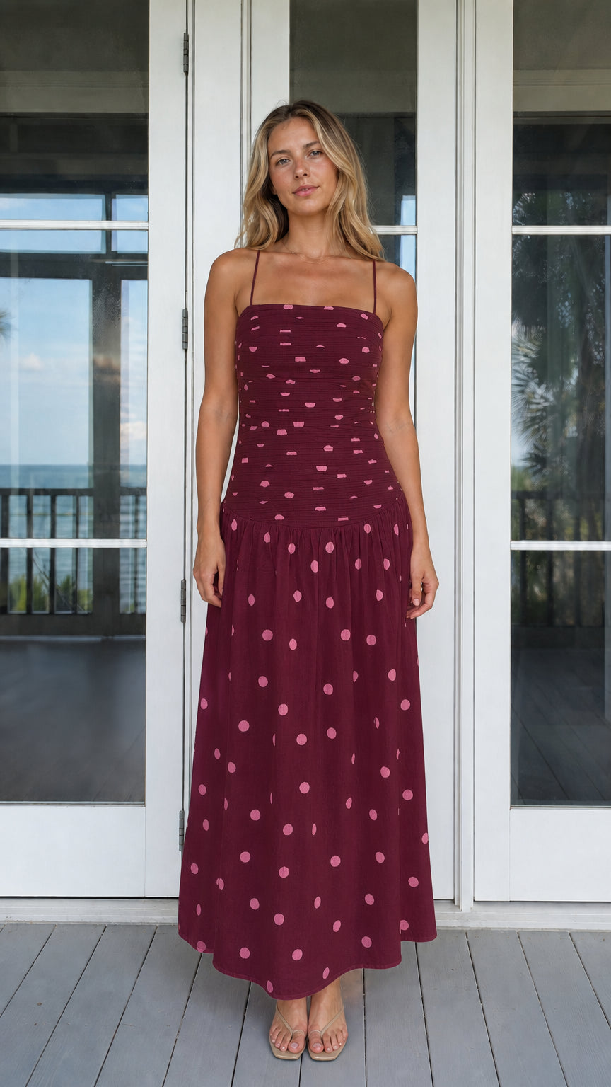 Model wearing burgundy polka dot smocked maxi dress