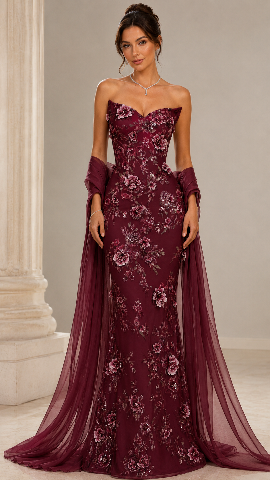 Front view of burgundy floral strapless formal gown with sheer wrap