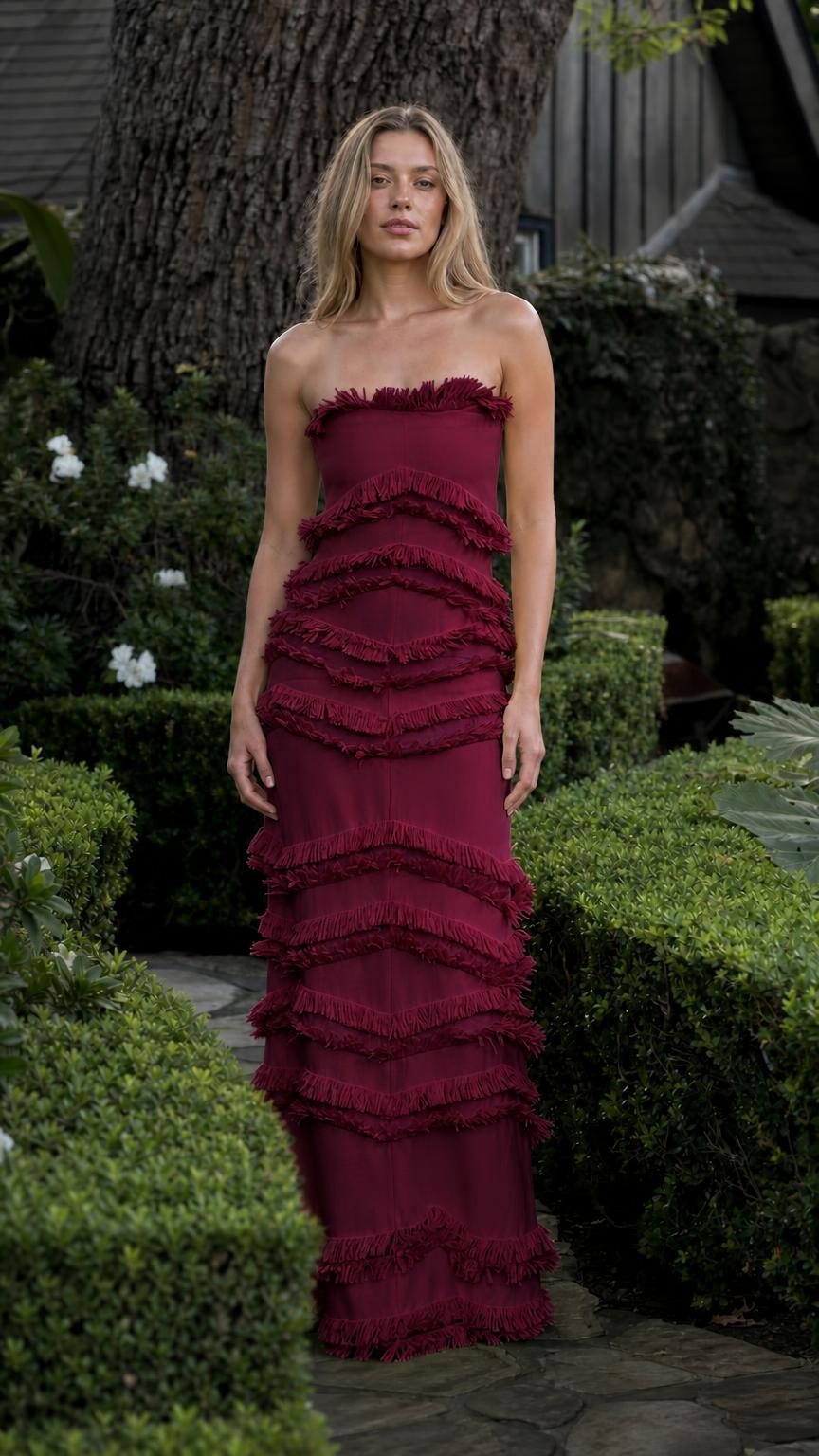 Model wearing burgundy tiered fringe strapless maxi dress