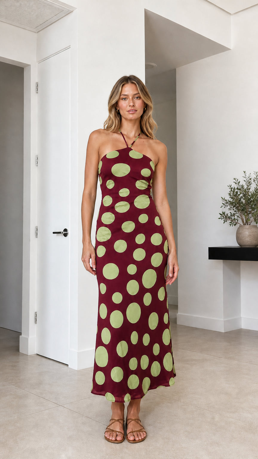 Model wearing burgundy polka dot halter midi dress
