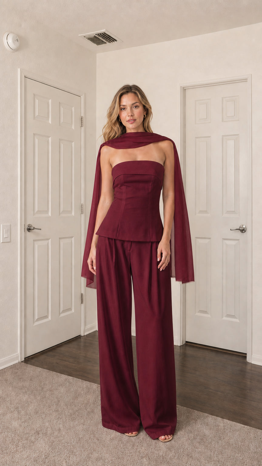 Front view of model wearing burgundy strapless top, wide-leg pants, and scarf