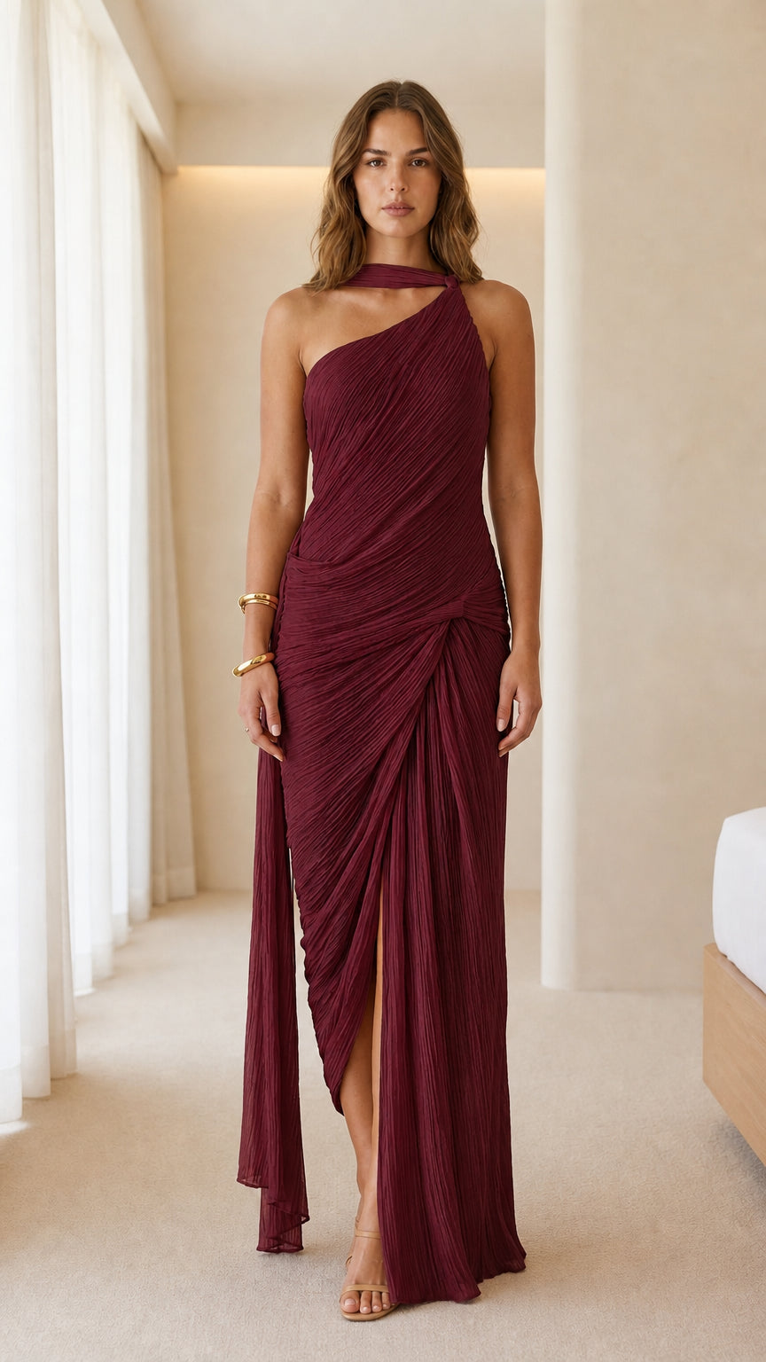 Front view of woman wearing burgundy one-shoulder pleated maxi dress