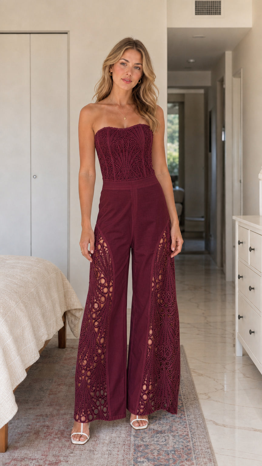 Front view of woman wearing burgundy strapless lace panel jumpsuit