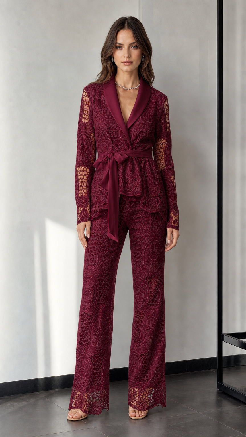Woman wearing burgundy lace blazer and trousers set
