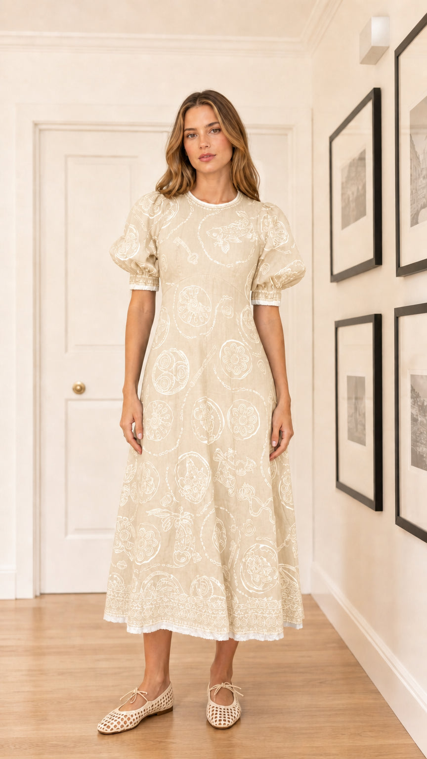 Woman wearing cream colored embroidered puff sleeve midi dress